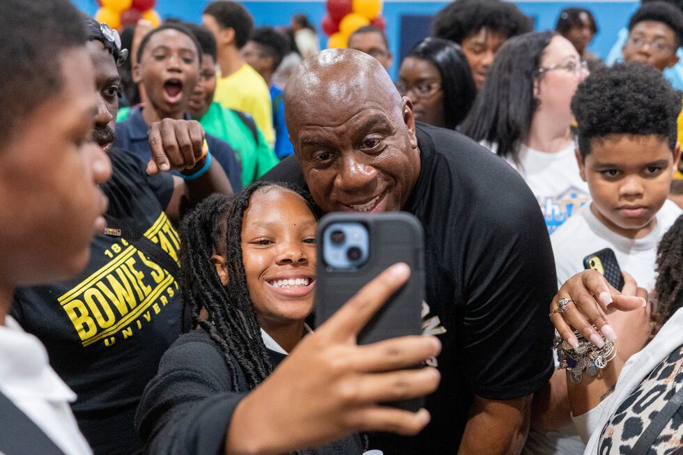 Washington Commanders part-owner Magic Johnson takes a selfie with children at the Boys &...