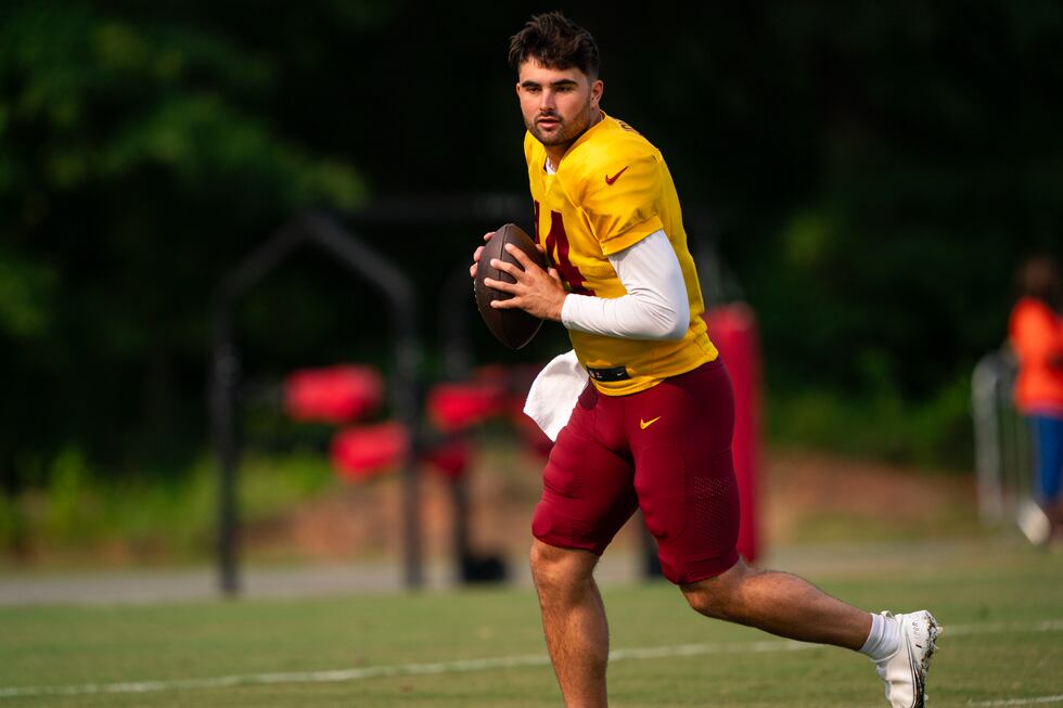 Washington Commanders quarterback Sam Howell participates in a drill during an NFL football...