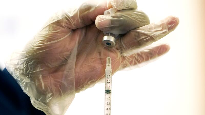 FILE - A nurse loads a syringe with the child's dose of the Pfizer COVID-19 vaccine prior to...