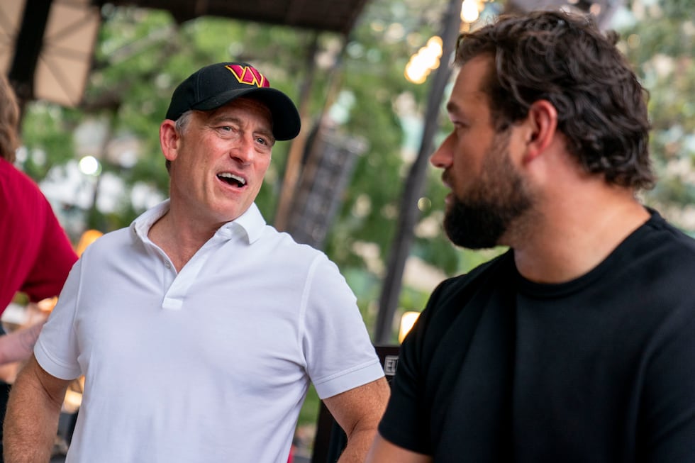 Josh Harris, left, one of the new owners of the Washington Commanders, speaks with offensive...