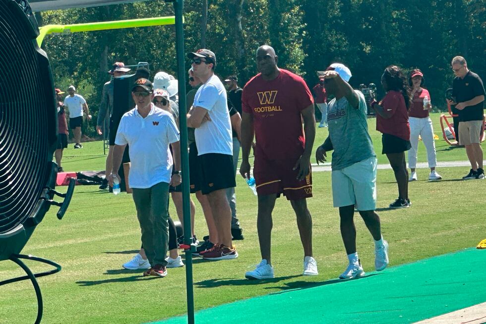Washington Commanders owners Josh Harris, front left and Magic Johnson, second from right,...