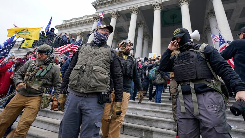 FILE - Members of the Oath Keepers extremist group stand on the East Front of the U.S. Capitol...